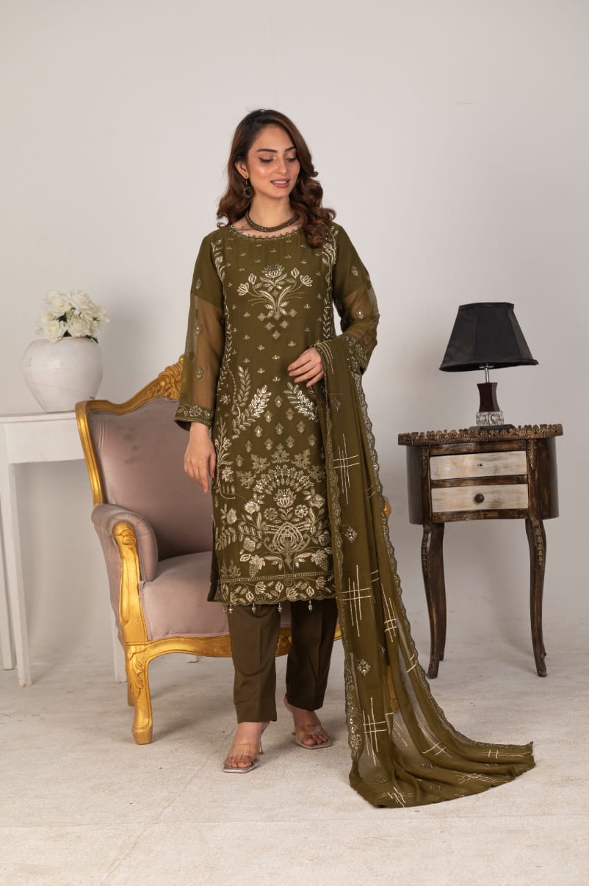 Woman posing in a green embroidered outfit