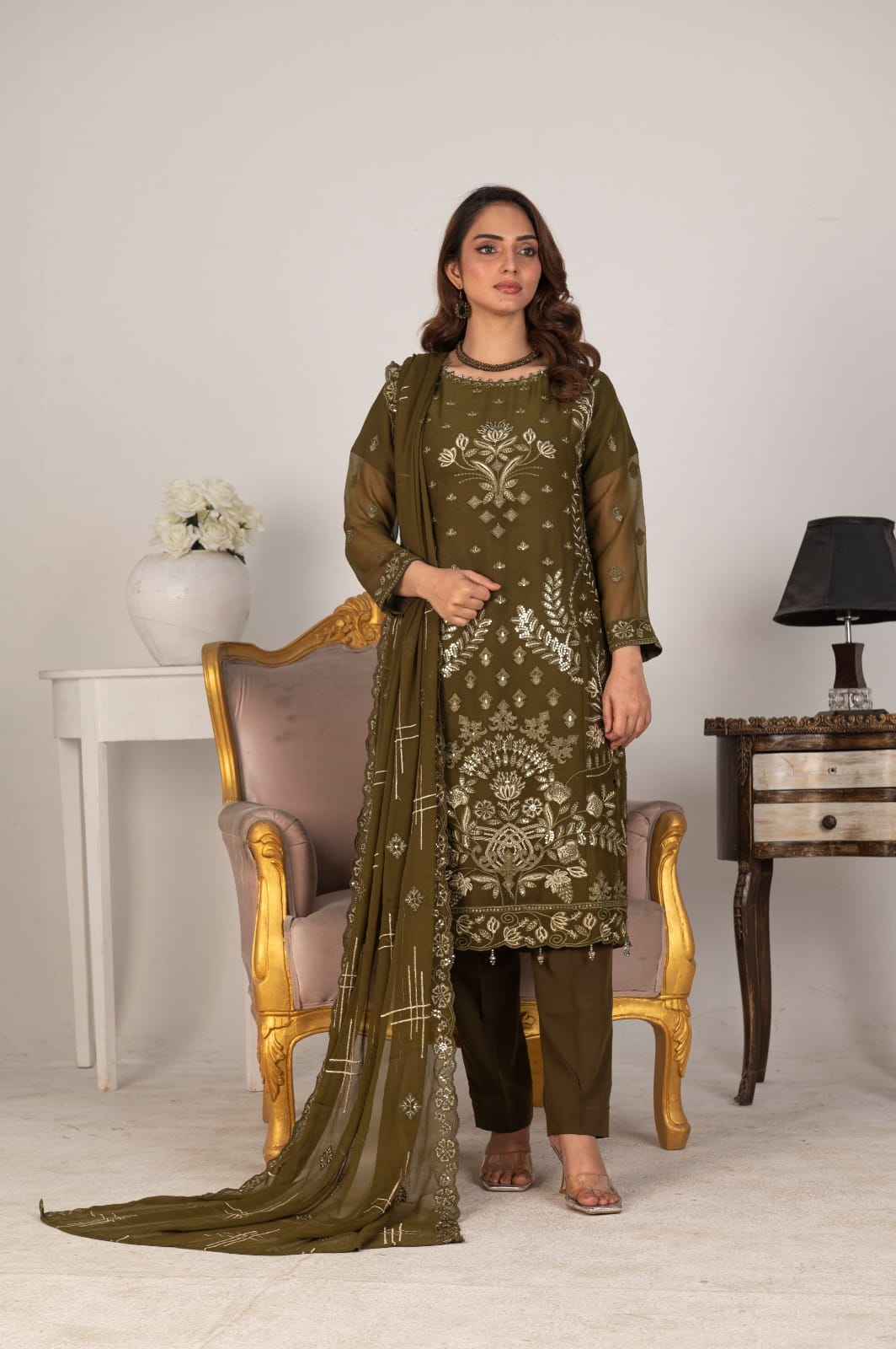 Woman in a green embroidered outfit with a matching dupatta