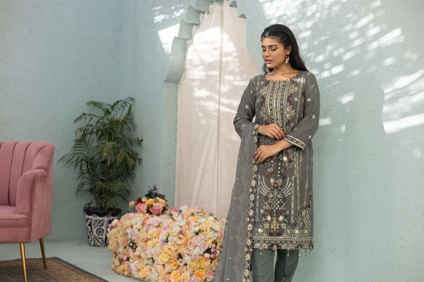 Woman in a gray embroidered chiffon shalwar kameez pose