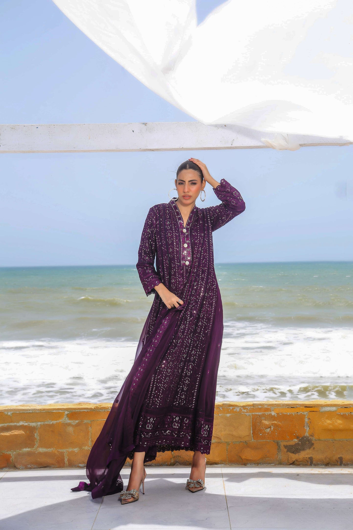 Model posing in dark purple embroidered maxi