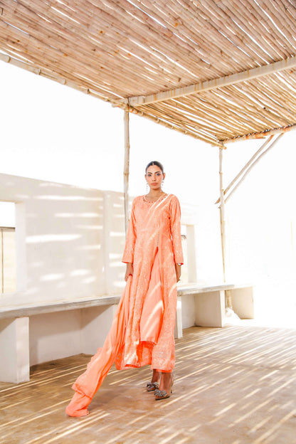 Model twirling in melon chiffon frock