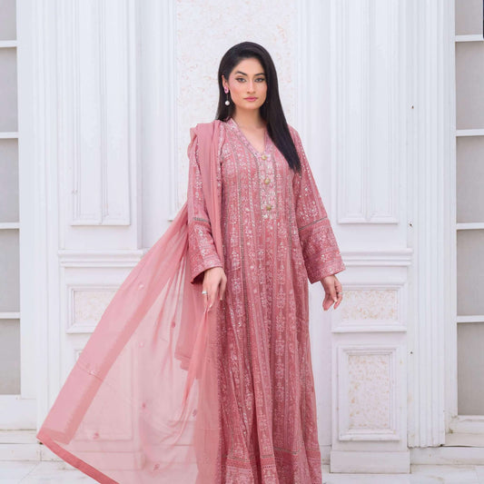 Woman wearing a pink traditional maxi outfit with a white background